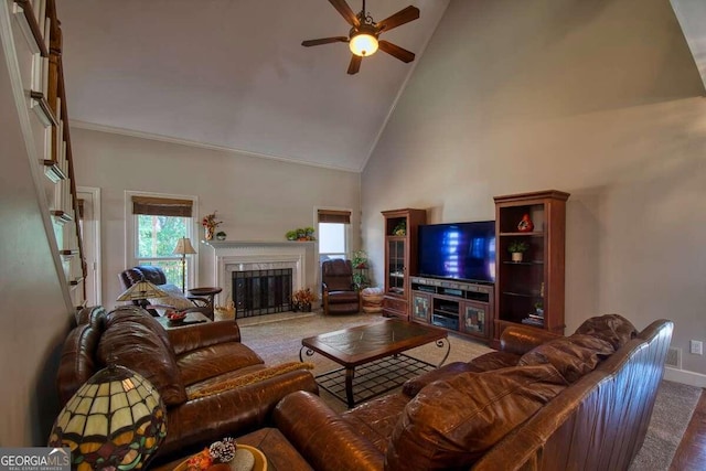 carpeted living room featuring high vaulted ceiling, a fireplace, a ceiling fan, baseboards, and ornamental molding