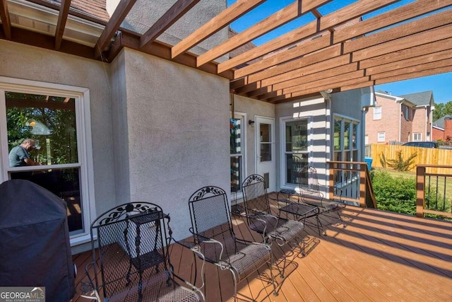 view of patio featuring outdoor dining area, fence, a wooden deck, and a pergola