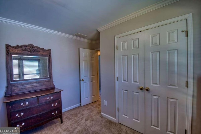 carpeted bedroom featuring visible vents, a closet, baseboards, and crown molding