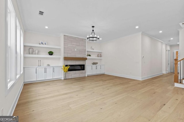 3636 Castoff Ct, Gainesville, GA 30506 - unfurnished living room with a fireplace, a notable chandelier, visible vents, stairway, and light wood-style floors