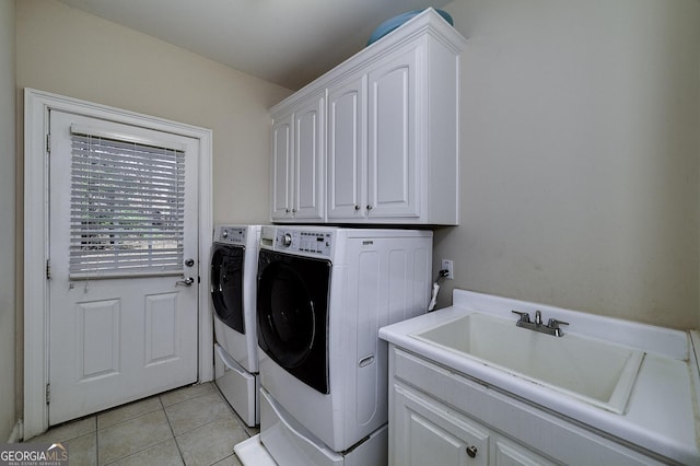 washroom with light tile patterned floors, cabinet space, a sink, and separate washer and dryer