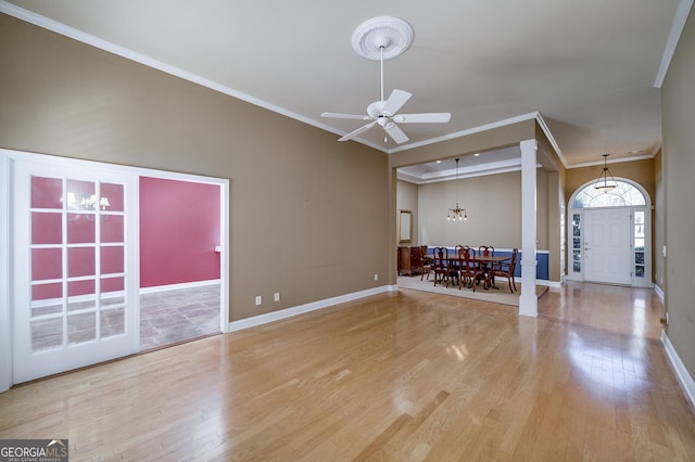 unfurnished living room featuring ornamental molding, baseboards, and wood finished floors