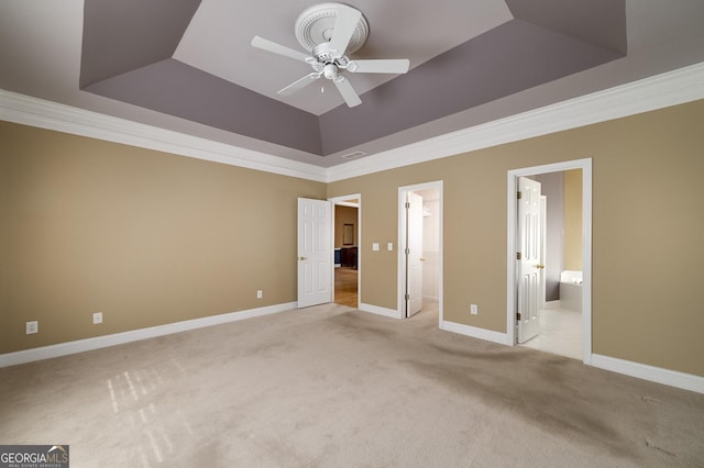 unfurnished bedroom featuring a tray ceiling, light colored carpet, and crown molding