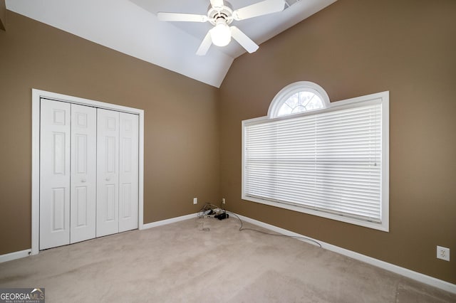 unfurnished bedroom with carpet floors, baseboards, vaulted ceiling, and a closet