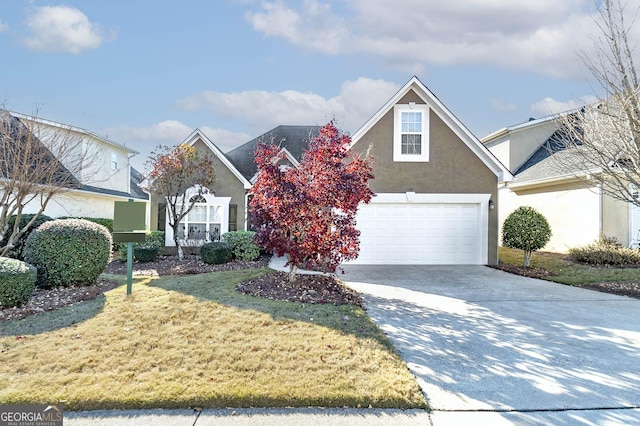 traditional-style house featuring a garage, concrete driveway, a front lawn, and stucco siding