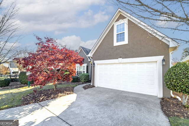 traditional-style home featuring concrete driveway and stucco siding