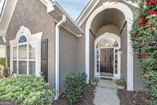 entrance to property featuring stucco siding