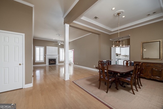 dining room with light wood-type flooring, visible vents, and a fireplace