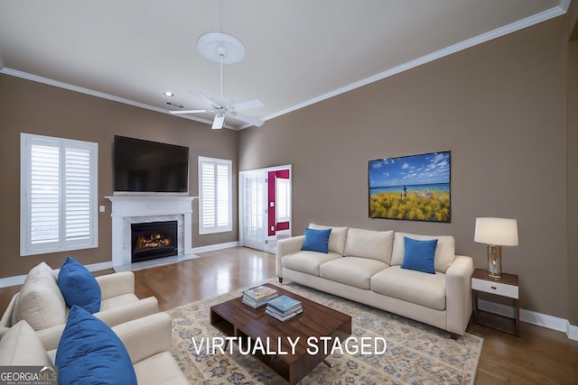 living room featuring a fireplace, wood finished floors, visible vents, baseboards, and ornamental molding