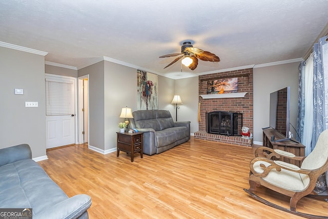 living room featuring ornamental molding, light wood finished floors, a fireplace, and baseboards