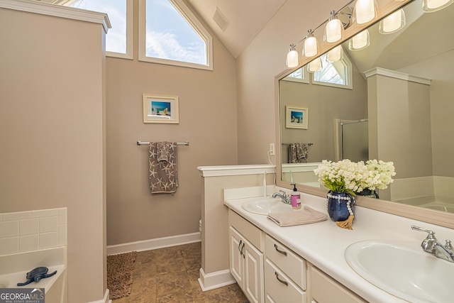 full bath featuring vaulted ceiling, a garden tub, a sink, and visible vents