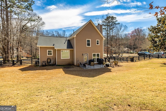 rear view of property featuring a chimney, fence, and a lawn