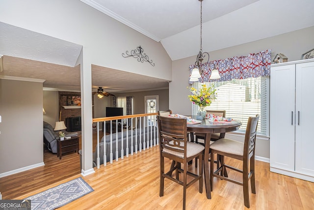 dining area featuring lofted ceiling, light wood finished floors, a ceiling fan, and crown molding