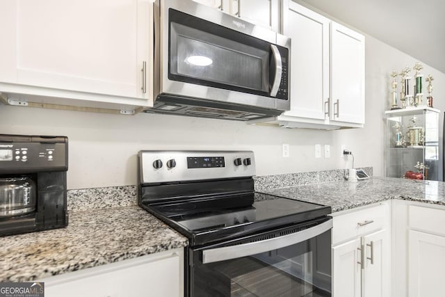 kitchen featuring light stone countertops, white cabinetry, and stainless steel appliances