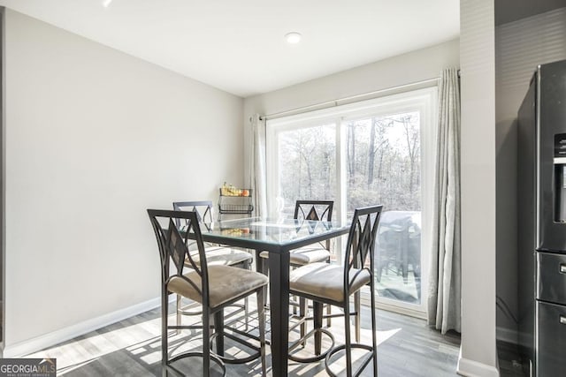 dining area with light wood-type flooring and baseboards