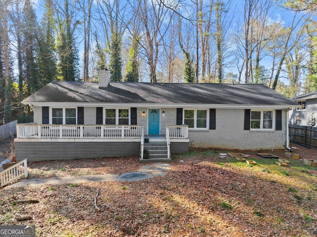 single story home with brick siding, a chimney, and fence