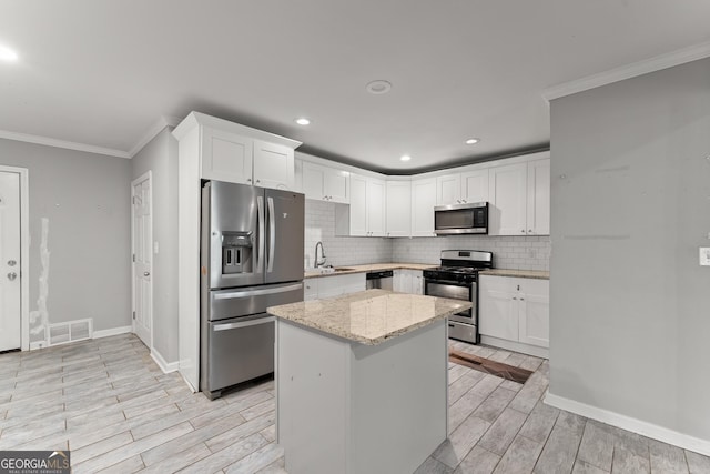 kitchen with appliances with stainless steel finishes, wood tiled floor, visible vents, and a sink