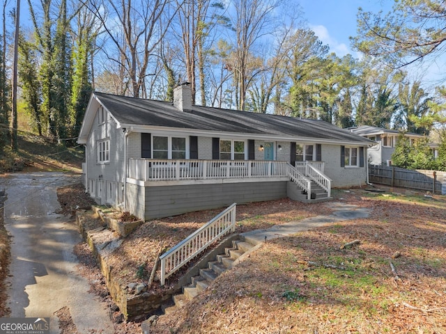 single story home with stairway, brick siding, fence, and a chimney