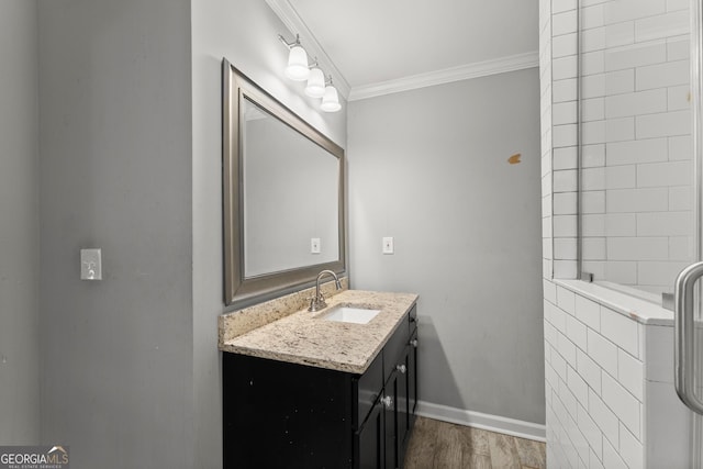 bathroom with crown molding, vanity, baseboards, and wood finished floors