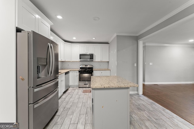 kitchen with decorative backsplash, a center island, wood tiled floor, stainless steel appliances, and white cabinetry