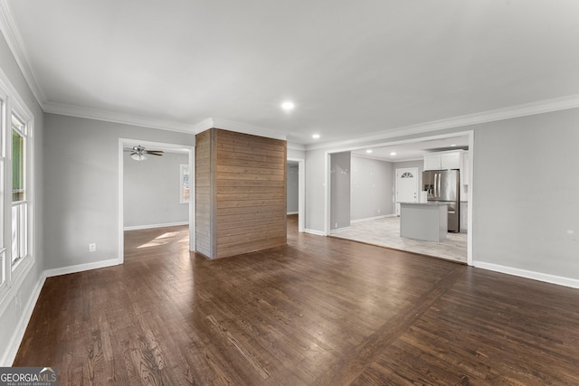 unfurnished living room featuring crown molding, baseboards, wood finished floors, and recessed lighting