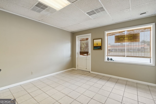 empty room with a paneled ceiling, visible vents, and baseboards