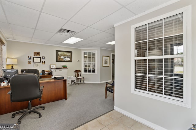 carpeted office with visible vents, ornamental molding, a drop ceiling, baseboards, and tile patterned floors