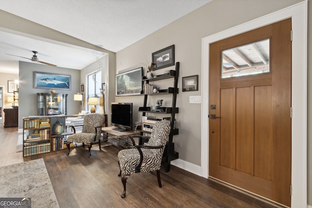 foyer entrance featuring wood finished floors, a ceiling fan, and baseboards