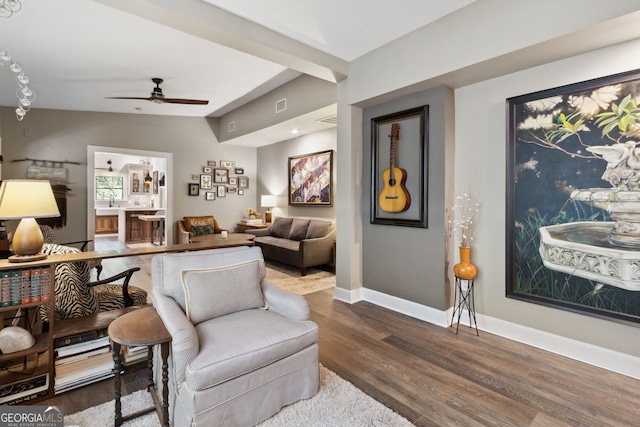 sitting room with visible vents, baseboards, a ceiling fan, lofted ceiling, and wood finished floors