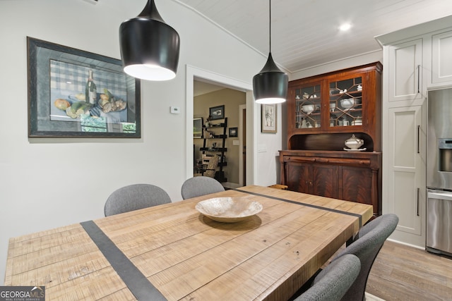 dining area featuring lofted ceiling, light wood-style flooring, and recessed lighting