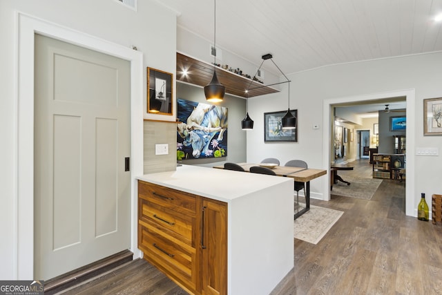 kitchen with wood ceiling, light countertops, brown cabinets, dark wood-style floors, and tasteful backsplash