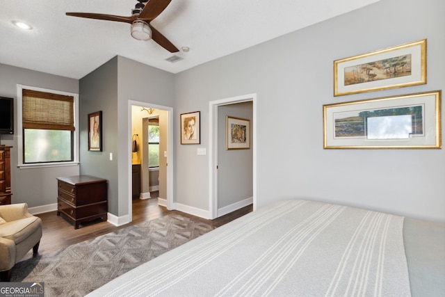 bedroom featuring multiple windows, wood finished floors, visible vents, and baseboards