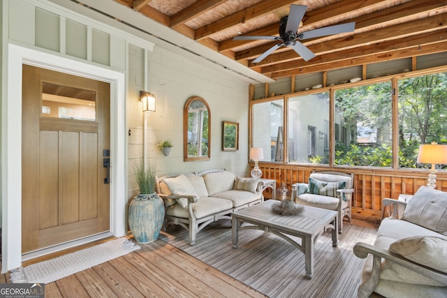 sunroom with ceiling fan and beamed ceiling