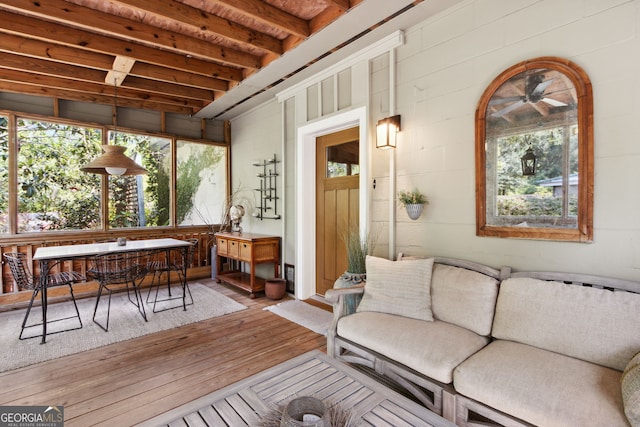 sunroom / solarium featuring beamed ceiling and plenty of natural light