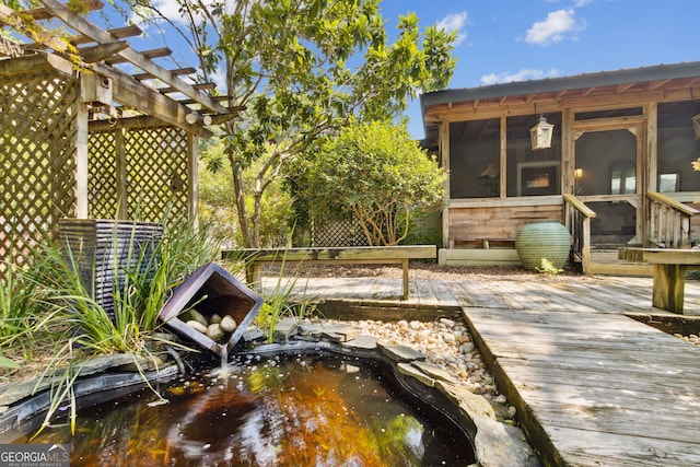 wooden deck featuring a sunroom and a pergola