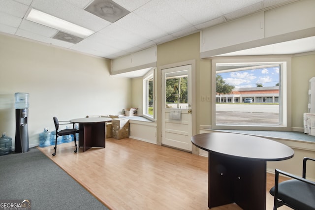 interior space with light wood-style floors and a drop ceiling