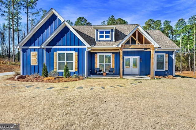 view of front of property featuring board and batten siding, french doors, and roof with shingles