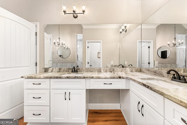 bathroom featuring wood finished floors, a sink, and an inviting chandelier