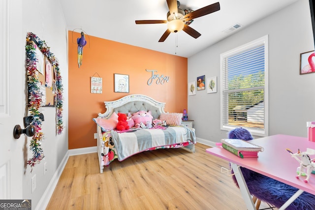 bedroom with visible vents, baseboards, and wood finished floors