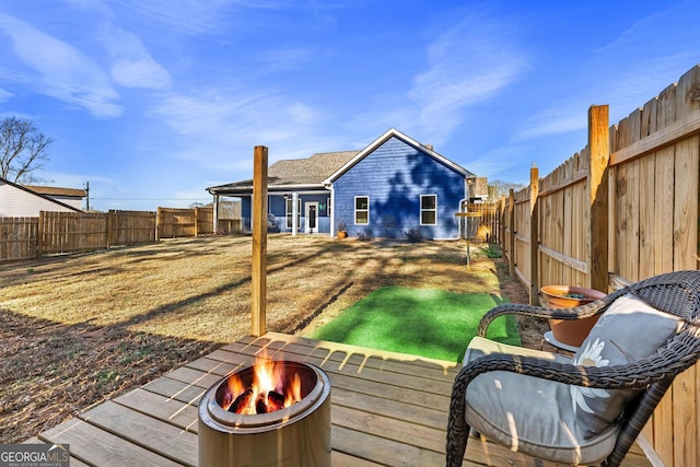 back of property with an outdoor fire pit and a fenced backyard