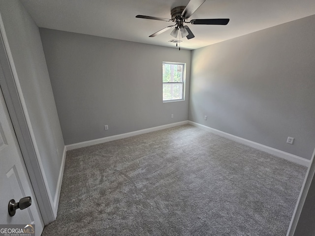 carpeted empty room with ceiling fan, visible vents, and baseboards