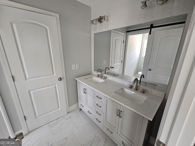 bathroom with marble finish floor, double vanity, and a sink