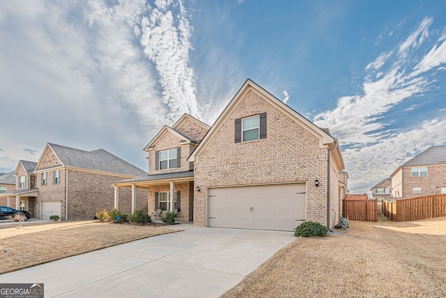 traditional home featuring driveway, brick siding, an attached garage, and fence