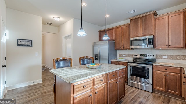 kitchen featuring appliances with stainless steel finishes, backsplash, and visible vents