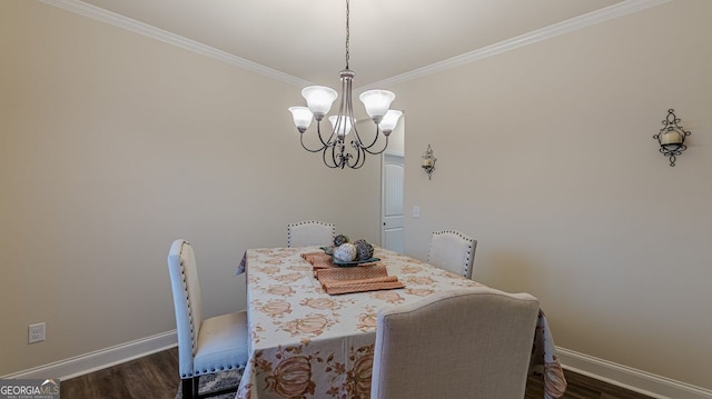 dining room with a chandelier, dark wood finished floors, baseboards, and ornamental molding