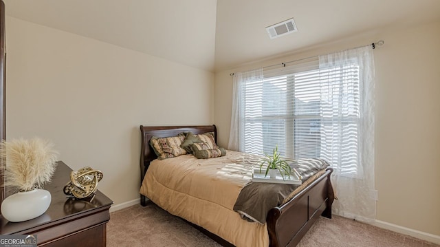 bedroom featuring baseboards, vaulted ceiling, visible vents, and light colored carpet