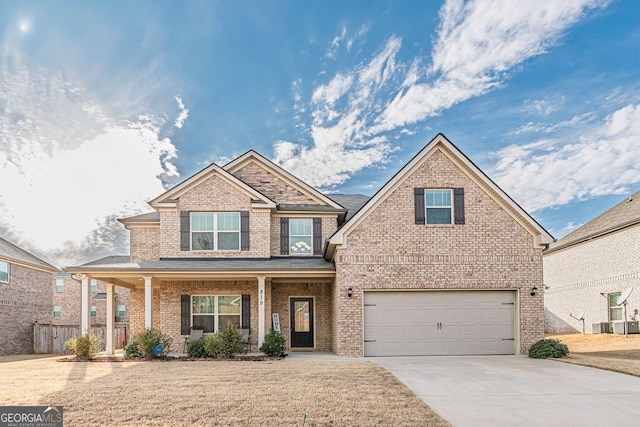 craftsman-style home with covered porch, brick siding, driveway, and an attached garage