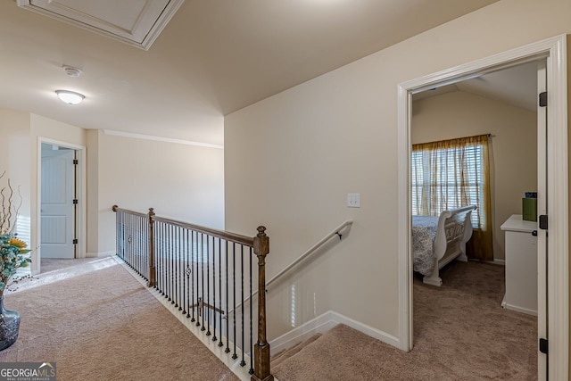 corridor featuring carpet, baseboards, and an upstairs landing