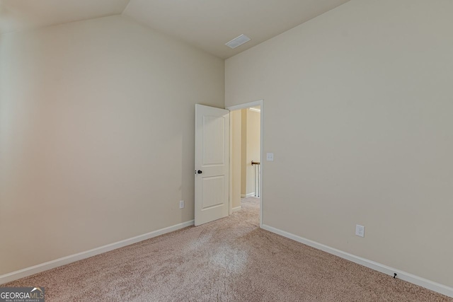 unfurnished room featuring lofted ceiling, visible vents, baseboards, and carpet flooring