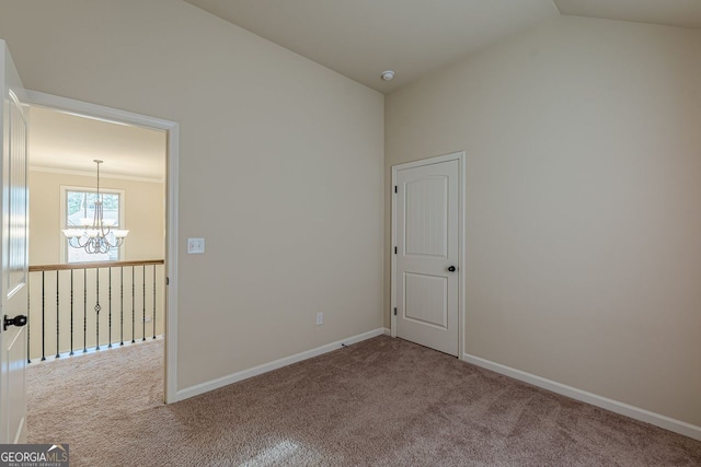 carpeted empty room featuring baseboards, a chandelier, vaulted ceiling, and ornamental molding